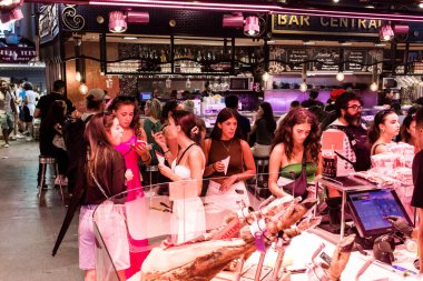 Barselona, İspanya - 28 Ağustos 2023 İspanya 'nın başkenti Barcelona' daki Boqueria gıda pazarında keyif çatan turistler.