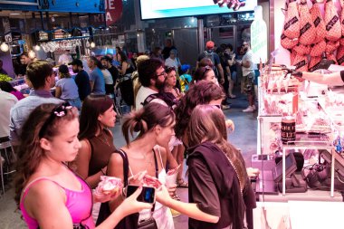 Barselona, İspanya - 28 Ağustos 2023 İspanya 'nın başkenti Barcelona' daki Boqueria gıda pazarında keyif çatan turistler.