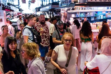 Barselona, İspanya - 28 Ağustos 2023 İspanya 'nın başkenti Barcelona' daki Boqueria gıda pazarında keyif çatan turistler.