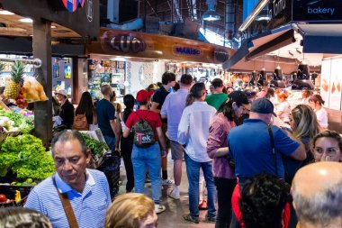 Barselona, İspanya - 28 Ağustos 2023 İspanya 'nın başkenti Barcelona' daki Boqueria gıda pazarında keyif çatan turistler.