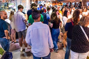 Barselona, İspanya - 28 Ağustos 2023 İspanya 'nın başkenti Barcelona' daki Boqueria gıda pazarında keyif çatan turistler.