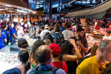 Barselona, İspanya - 28 Ağustos 2023 İspanya 'nın başkenti Barcelona' daki Boqueria gıda pazarında keyif çatan turistler.