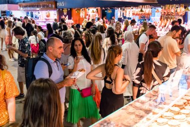 Barselona, İspanya - 28 Ağustos 2023 İspanya 'nın başkenti Barcelona' daki Boqueria gıda pazarında keyif çatan turistler.