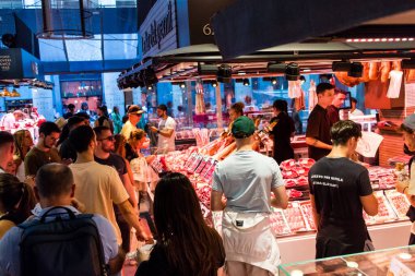 Barselona, İspanya - 28 Ağustos 2023 İspanya 'nın başkenti Barcelona' daki Boqueria gıda pazarında keyif çatan turistler.