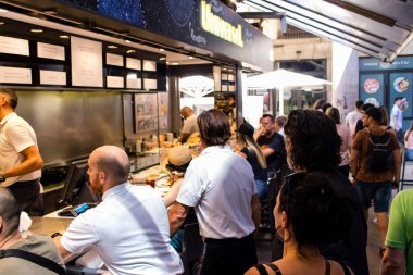 Barselona, İspanya - 28 Ağustos 2023 İspanya 'nın başkenti Barcelona' daki Boqueria gıda pazarında keyif çatan turistler.