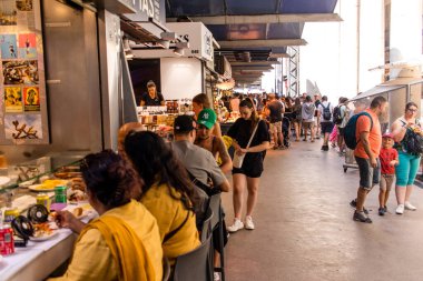 Barselona, İspanya - 28 Ağustos 2023 İspanya 'nın başkenti Barcelona' daki Boqueria gıda pazarında keyif çatan turistler.