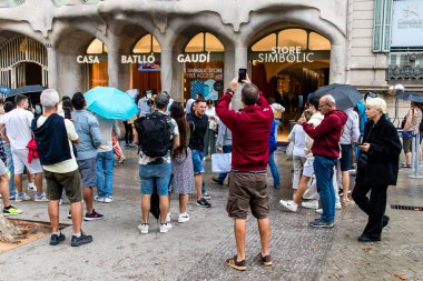 Barselona, İspanya - 28 Ağustos 2023 İspanya 'nın simgesel şehri ve Katalonya' nın başkenti Barcelona 'daki Gaudi evinin yakınında yürüyen turistler.