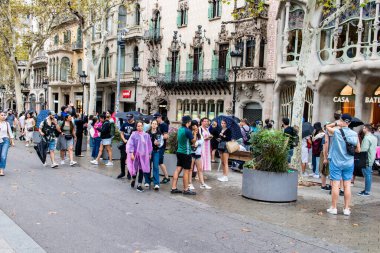 Barselona, İspanya - 28 Ağustos 2023 İspanya 'nın simgesel şehri ve Katalonya' nın başkenti Barcelona 'daki Gaudi evinin yakınında yürüyen turistler.