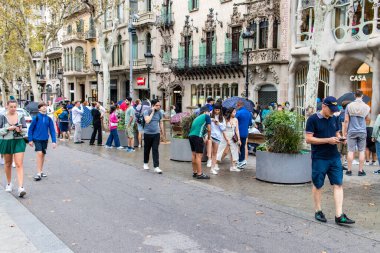 Barselona, İspanya - 28 Ağustos 2023 İspanya 'nın simgesel şehri ve Katalonya' nın başkenti Barcelona 'daki Gaudi evinin yakınında yürüyen turistler.