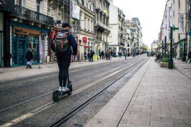 Reims, Fransa - 26 Ekim 2023 Reims sokaklarında elektrikli scooter kullanan insanlar, küçük bir iç yanmalı motorlar ve merkezde bir güverte ile çalışıyorlar.