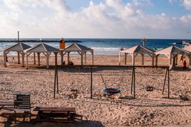 Tel Aviv, İsrail - 14 Aralık 2023 Plajları temizlikleriyle bilinir. İnsanlar sık sık sörf yapmak, yüzmek ve güneşlenmek için oraya giderler. İsrail 'de hava sıcaklığı her gün kumsala gitmenize izin veriyor..