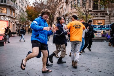 Kudüs, İsrail - 21 Aralık 2023 Genç İsrailli gönüllüler Kudüs 'teki Jaffa caddesinde bir yardım derneği için dans gösterisi düzenliyorlar.