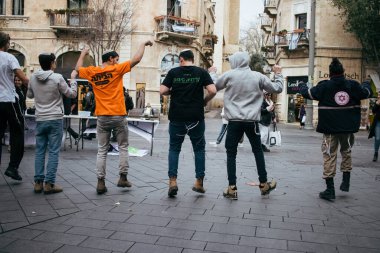 Kudüs, İsrail - 21 Aralık 2023 Genç İsrailli gönüllüler Kudüs 'teki Jaffa caddesinde bir yardım derneği için dans gösterisi düzenliyorlar.