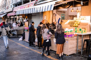 Kudüs, İsrail - 22 Aralık 2023 Mahane Yehuda Pazarı 'nda alışveriş yapan insanlar, genellikle 