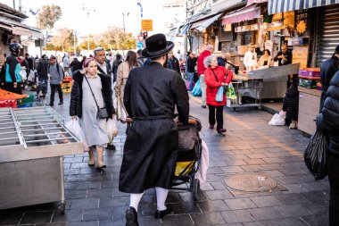 Kudüs, İsrail - 22 Aralık 2023 Mahane Yehuda Pazarı 'nda alışveriş yapan insanlar, genellikle 