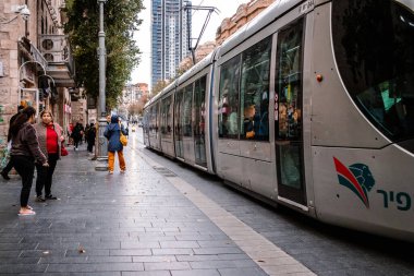 Kudüs, İsrail - 22 Aralık 2023 Modern elektrikli tramvay İsrail 'de Kudüs sokaklarında ilerliyor.