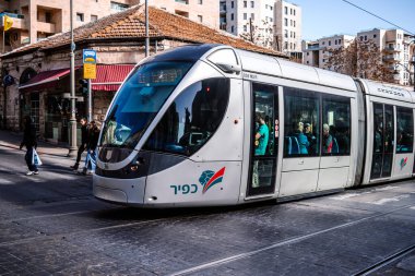 Kudüs, İsrail - 22 Aralık 2023 Modern elektrikli tramvay İsrail 'de Kudüs sokaklarında ilerliyor.