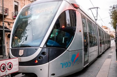 Kudüs, İsrail - 22 Aralık 2023 Modern elektrikli tramvay İsrail 'de Kudüs sokaklarında ilerliyor.