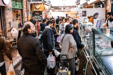 Kudüs, İsrail - 22 Aralık 2023 Mahane Yehuda Pazarı 'nda alışveriş yapan insanlar, genellikle 