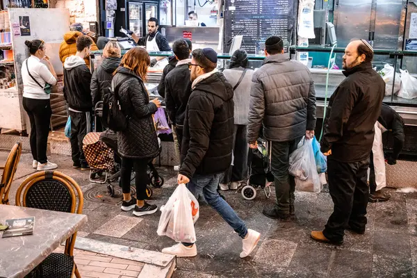 Kudüs, İsrail - 22 Aralık 2023 Mahane Yehuda Pazarı 'nda alışveriş yapan insanlar, genellikle 