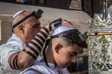 Kudüs, İsrail 28 Aralık 2023 'te bir Bar Mitzvah törenine katılan çocuk ve aile, İbrani geleneğine göre, Eski Kudüs şehrinin Batı Duvarı önünde bir dini tören düzenlenmiştir.