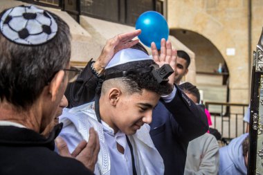 Kudüs, İsrail 28 Aralık 2023 'te bir Bar Mitzvah törenine katılan çocuk ve aile, İbrani geleneğine göre, Eski Kudüs şehrinin Batı Duvarı önünde bir dini tören düzenlenmiştir.