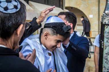 Kudüs, İsrail 28 Aralık 2023 'te bir Bar Mitzvah törenine katılan çocuk ve aile, İbrani geleneğine göre, Eski Kudüs şehrinin Batı Duvarı önünde bir dini tören düzenlenmiştir.