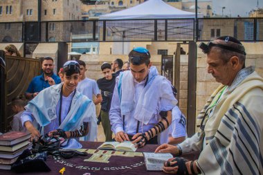 Kudüs, İsrail 28 Aralık 2023 'te bir Bar Mitzvah törenine katılan çocuk ve aile, İbrani geleneğine göre, Eski Kudüs şehrinin Batı Duvarı önünde bir dini tören düzenlenmiştir.