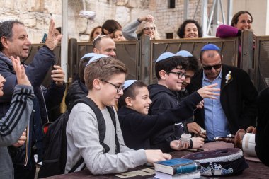 Kudüs, İsrail 28 Aralık 2023 'te bir Bar Mitzvah törenine katılan çocuk ve aile, İbrani geleneğine göre, Eski Kudüs şehrinin Batı Duvarı önünde bir dini tören düzenlenmiştir.