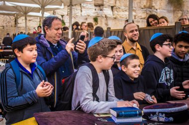 Kudüs, İsrail 28 Aralık 2023 'te bir Bar Mitzvah törenine katılan çocuk ve aile, İbrani geleneğine göre, Eski Kudüs şehrinin Batı Duvarı önünde bir dini tören düzenlenmiştir.