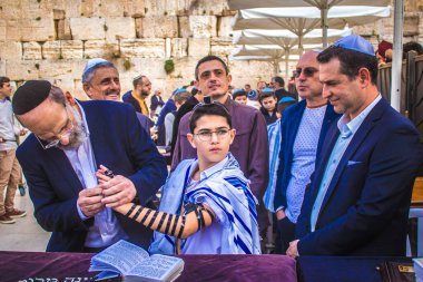 Kudüs, İsrail 28 Aralık 2023 'te bir Bar Mitzvah törenine katılan çocuk ve aile, İbrani geleneğine göre, Eski Kudüs şehrinin Batı Duvarı önünde bir dini tören düzenlenmiştir.
