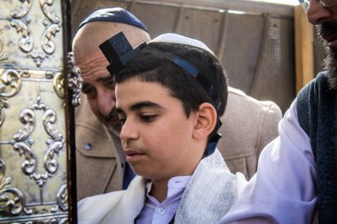 Kudüs, İsrail 28 Aralık 2023 'te bir Bar Mitzvah törenine katılan çocuk ve aile, İbrani geleneğine göre, Eski Kudüs şehrinin Batı Duvarı önünde bir dini tören düzenlenmiştir.