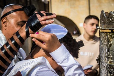 Kudüs, İsrail 28 Aralık 2023 'te bir Bar Mitzvah törenine katılan çocuk ve aile, İbrani geleneğine göre, Eski Kudüs şehrinin Batı Duvarı önünde bir dini tören düzenlenmiştir.