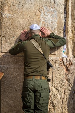 Kudüs, İsrail 28 Aralık 2023 bir IDF askeri Kudüs 'teki Batı Duvarı' nda dua ediyor. Askerler düzenli olarak savaş teçhizatlarıyla ve saldırı tüfekleriyle taburlarına katılmadan önce dua etmeye gelirler..