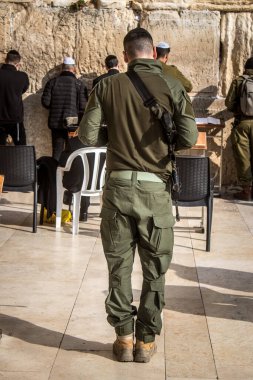 Kudüs, İsrail 28 Aralık 2023 bir IDF askeri Kudüs 'teki Batı Duvarı' nda dua ediyor. Askerler düzenli olarak savaş teçhizatlarıyla ve saldırı tüfekleriyle taburlarına katılmadan önce dua etmeye gelirler..