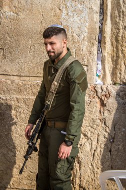 Kudüs, İsrail 28 Aralık 2023 bir IDF askeri Kudüs 'teki Batı Duvarı' nda dua ediyor. Askerler düzenli olarak savaş teçhizatlarıyla ve saldırı tüfekleriyle taburlarına katılmadan önce dua etmeye gelirler..