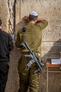 Kudüs, İsrail 28 Aralık 2023 bir IDF askeri Kudüs 'teki Batı Duvarı' nda dua ediyor. Askerler düzenli olarak savaş teçhizatlarıyla ve saldırı tüfekleriyle taburlarına katılmadan önce dua etmeye gelirler..