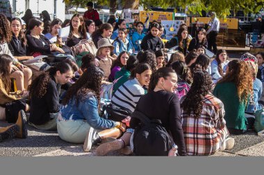 Tel Aviv, İsrail - 4 Ocak 2024 İsrailli gençler Tel Aviv 'deki Rehine Meydanı' nda hala Gazze 'de tutulan 129 rehinenin anısına şarkı söylüyorlar. İnsanlar düzenli olarak rehine ailelerini desteklemek için toplanır.