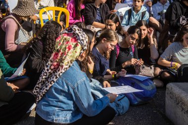 Tel Aviv, İsrail - 4 Ocak 2024 İsrailli gençler Tel Aviv 'deki Rehine Meydanı' nda hala Gazze 'de tutulan 129 rehinenin anısına şarkı söylüyorlar. İnsanlar düzenli olarak rehine ailelerini desteklemek için toplanır.