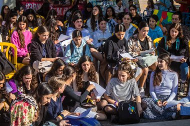 Tel Aviv, İsrail - 4 Ocak 2024 İsrailli gençler Tel Aviv 'deki Rehine Meydanı' nda hala Gazze 'de tutulan 129 rehinenin anısına şarkı söylüyorlar. İnsanlar düzenli olarak rehine ailelerini desteklemek için toplanır.