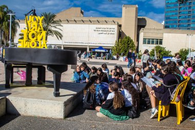 Tel Aviv, İsrail - 4 Ocak 2024 İsrailli gençler Tel Aviv 'deki Rehine Meydanı' nda hala Gazze 'de tutulan 129 rehinenin anısına şarkı söylüyorlar. İnsanlar düzenli olarak rehine ailelerini desteklemek için toplanır.