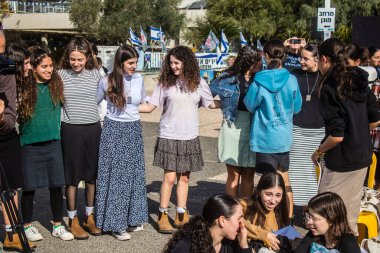 Tel Aviv, İsrail - 4 Ocak 2024 İsrailli gençler Tel Aviv 'deki Rehine Meydanı' nda hala Gazze 'de tutulan 129 rehinenin anısına şarkı söylüyorlar. İnsanlar düzenli olarak rehine ailelerini desteklemek için toplanır.