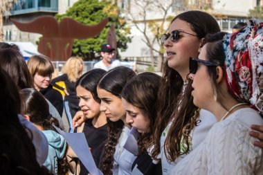 Tel Aviv, İsrail - 4 Ocak 2024 İsrailli gençler Tel Aviv 'deki Rehine Meydanı' nda hala Gazze 'de tutulan 129 rehinenin anısına şarkı söylüyorlar. İnsanlar düzenli olarak rehine ailelerini desteklemek için toplanır.