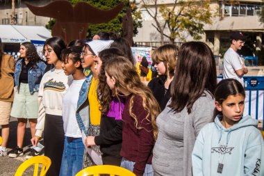 Tel Aviv, İsrail - 4 Ocak 2024 İsrailli gençler Tel Aviv 'deki Rehine Meydanı' nda hala Gazze 'de tutulan 129 rehinenin anısına şarkı söylüyorlar. İnsanlar düzenli olarak rehine ailelerini desteklemek için toplanır.