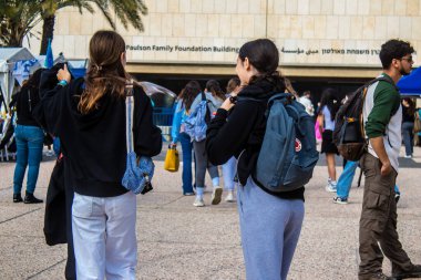 Tel Aviv, İsrail - 9 Ocak 2024 İsrailli gençler, şu anda Rehineler Meydanı olarak bilinen Tel Aviv Sanat Müzesine bir anma ziyareti için geliyorlar. Bugüne kadar 129 rehine Hamas 'ın elinde kaldı.