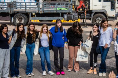 Tel Aviv, İsrail - 9 Ocak 2024 İsrailli gençler Tel Aviv 'deki Rehine Meydanı' nda hala Gazze 'de tutulan 129 rehinenin anısına şarkı söylüyorlar. İnsanlar düzenli olarak rehine ailelerini desteklemek için toplanır.