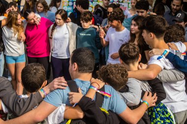 Tel Aviv, İsrail - 9 Ocak 2024 İsrailli gençler Tel Aviv 'deki Rehine Meydanı' nda hala Gazze 'de tutulan 129 rehinenin anısına şarkı söylüyorlar. İnsanlar düzenli olarak rehine ailelerini desteklemek için toplanır.