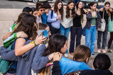 Tel Aviv, İsrail - 9 Ocak 2024 İsrailli gençler Tel Aviv 'deki Rehine Meydanı' nda hala Gazze 'de tutulan 129 rehinenin anısına şarkı söylüyorlar. İnsanlar düzenli olarak rehine ailelerini desteklemek için toplanır.