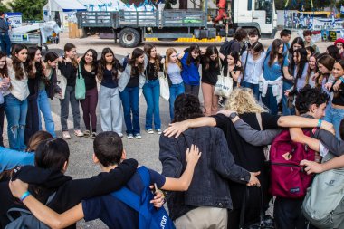 Tel Aviv, İsrail - 9 Ocak 2024 İsrailli gençler Tel Aviv 'deki Rehine Meydanı' nda hala Gazze 'de tutulan 129 rehinenin anısına şarkı söylüyorlar. İnsanlar düzenli olarak rehine ailelerini desteklemek için toplanır.