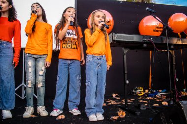 Tel Aviv, İsrail - 18 Ocak 2024 Genç kızlar, bugün 1 yaşına basan ve hala Hamas 'ın rehinesi olan Kfir' in en hüzünlü doğum günü münasebetiyle düzenlenen etkinlikte şarkı söyleyip katıldılar.